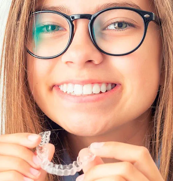 Person holding a removable clear aligner